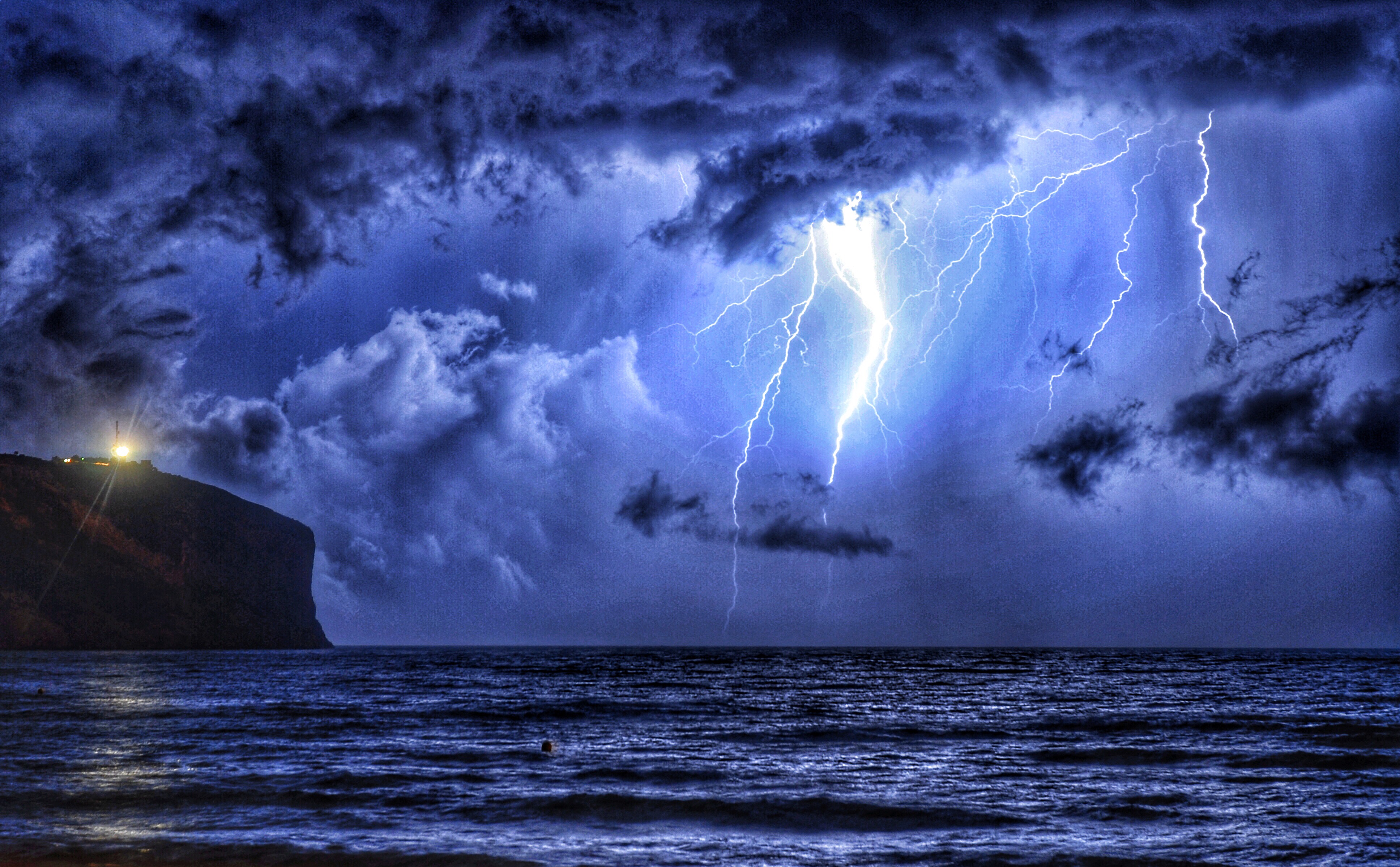 Extreme weather. Electric storm with forked lightning over the sea. Natural backgrounds