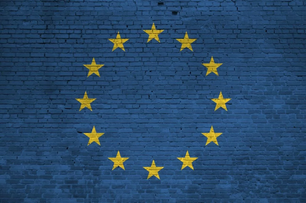 European union flag depicted in paint colors on old brick wall close up