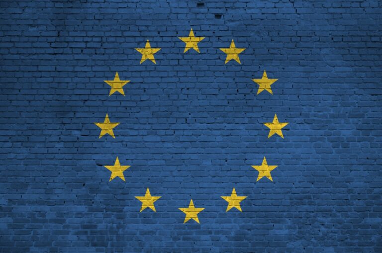 European union flag depicted in paint colors on old brick wall close up