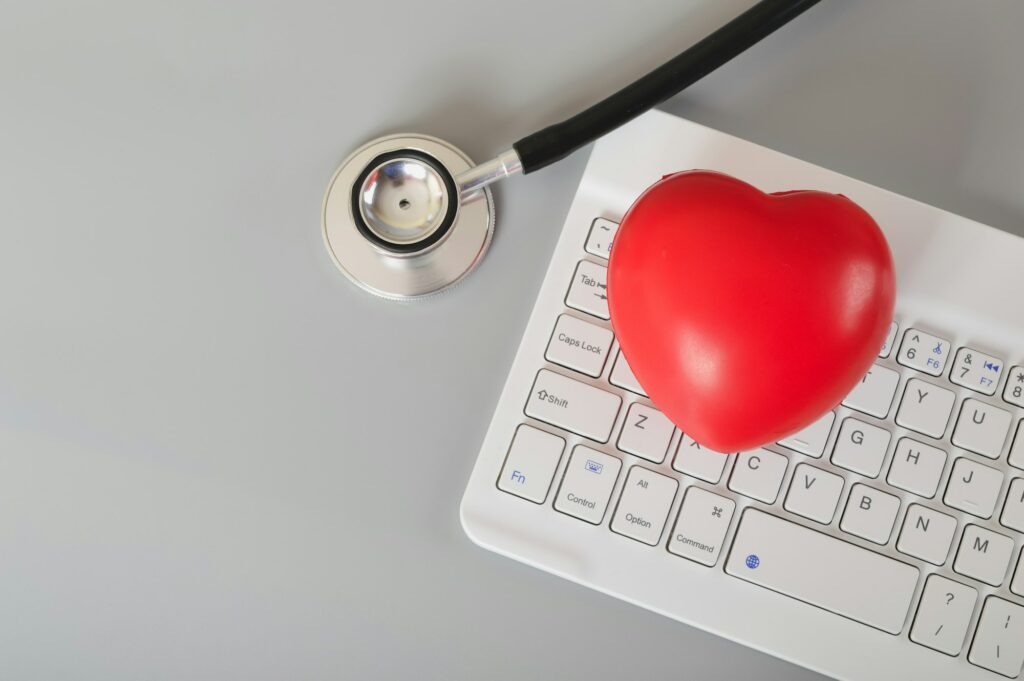 Stethoscope, red heart and computer keyboard. Online medical consultation concept.