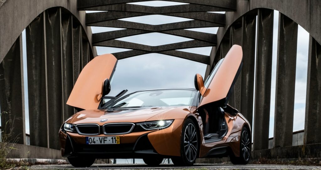 orange BMW i8 parked in middle of bridge