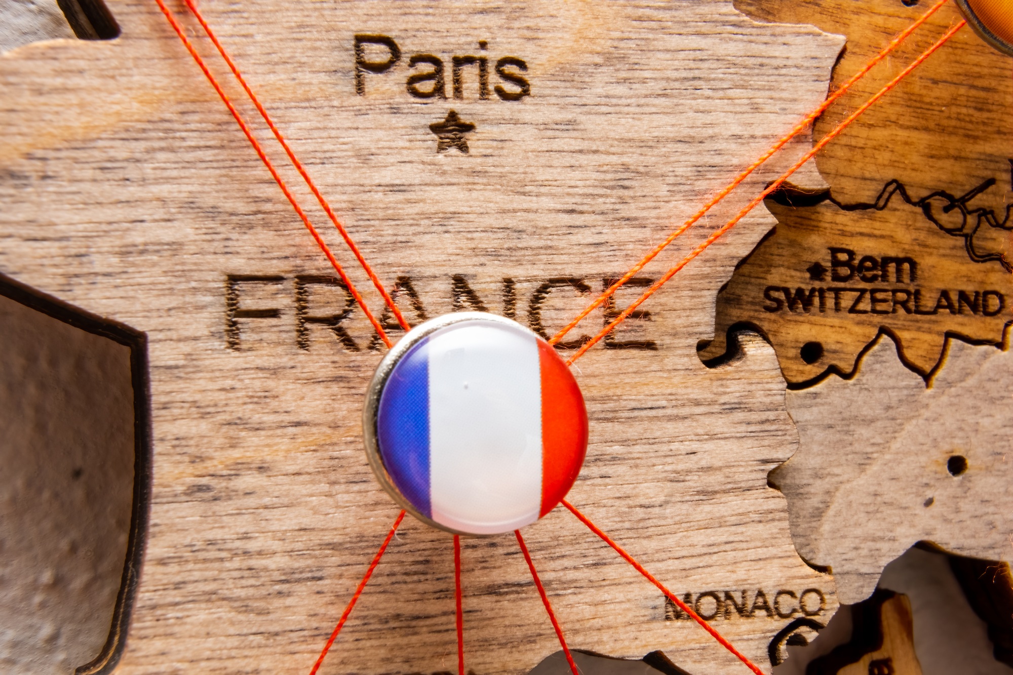 France flag on the pin with red thread showed the paths on the wooden map.