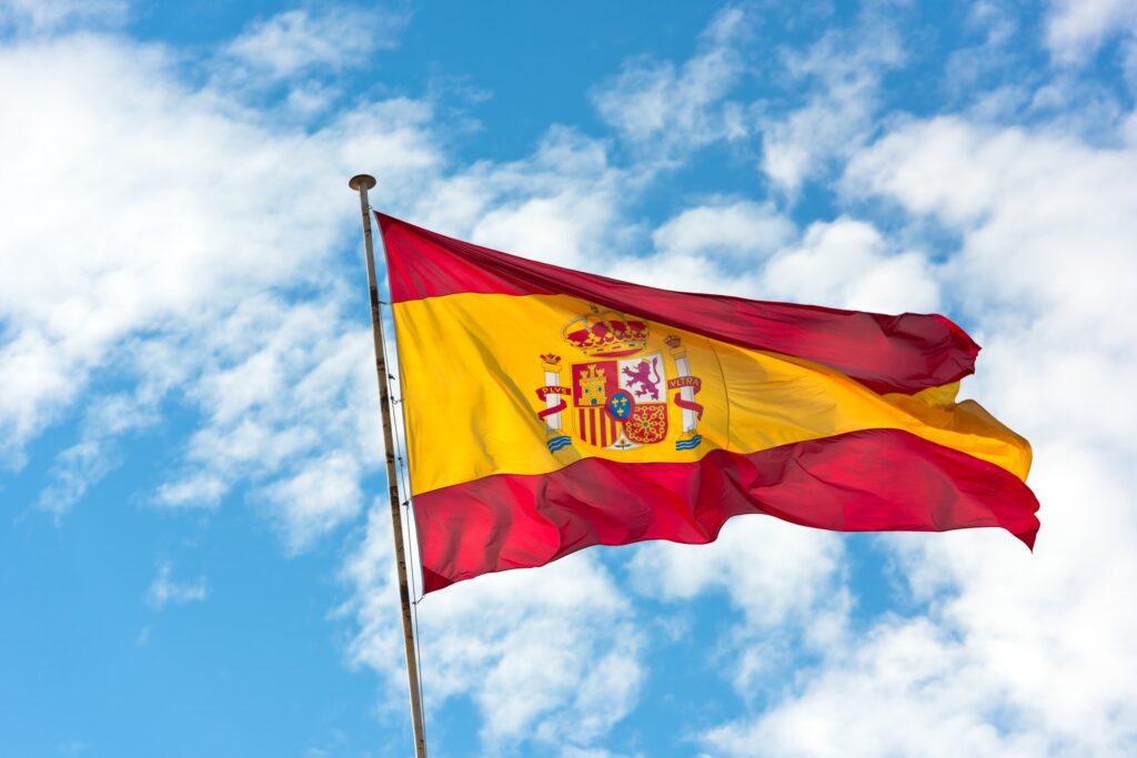 National Flag of Spain on blue sky background