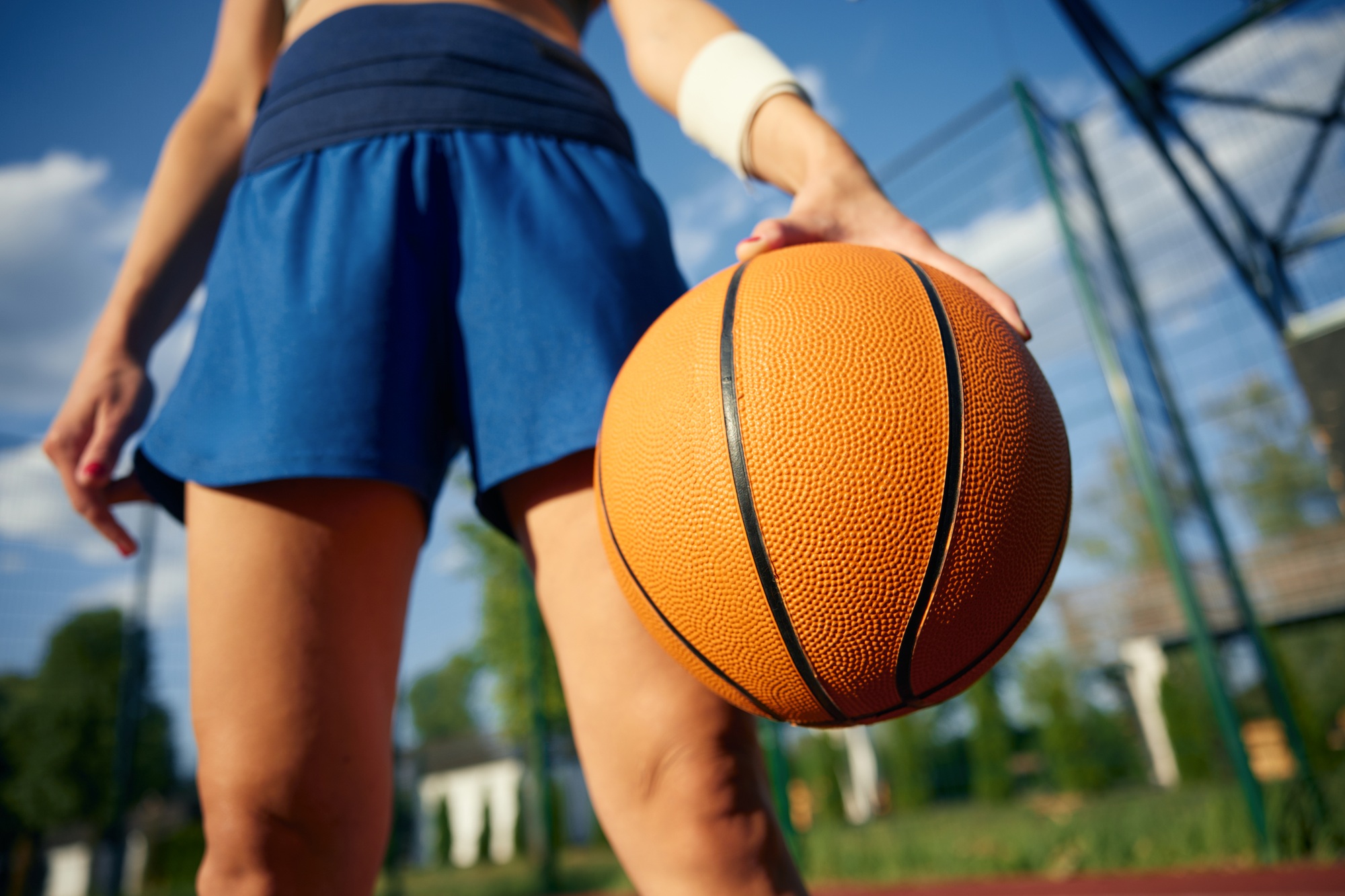 Bottom angle view of girl athlete with basketball ball