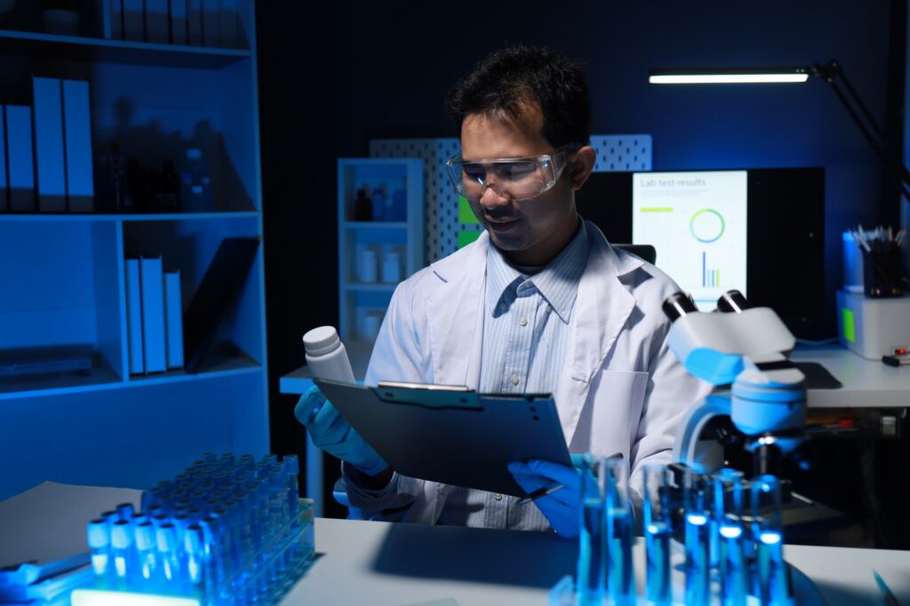 Chemist sitting and working in private drug laboratory, Biologists have acquired a new special drug