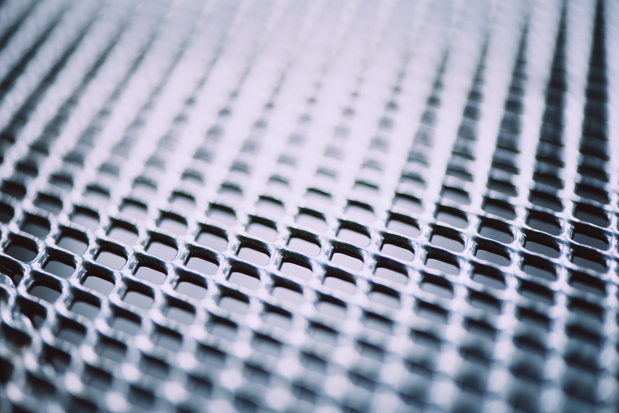 Metal background. Lattice texture with small cells grid. Selective focus point