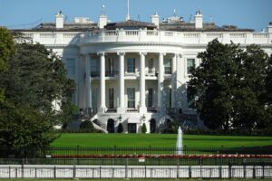 Front view of the iconic White House in Washington, DC, showing its lawn and fountain.
