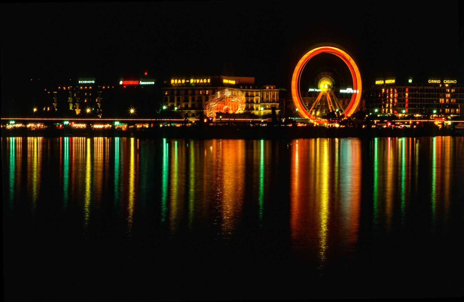 a ferris wheel in the middle of a lake at night