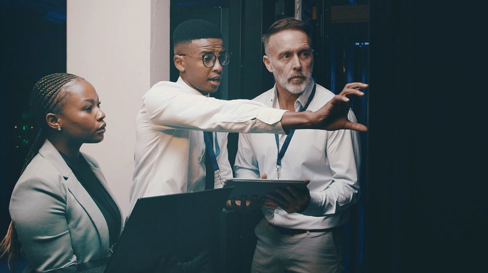 Three professionals standing in a data center