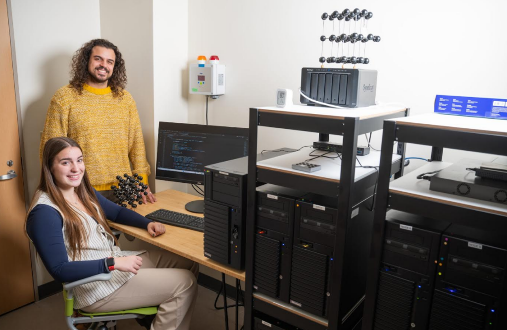 Physics majors Maggie Blanchard and Andre Correa working at the high-performance computing cluster in the CSCU Center for Quantum and Nanotechnology (QNT).