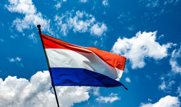 A red white and blue flag flying in the sky
