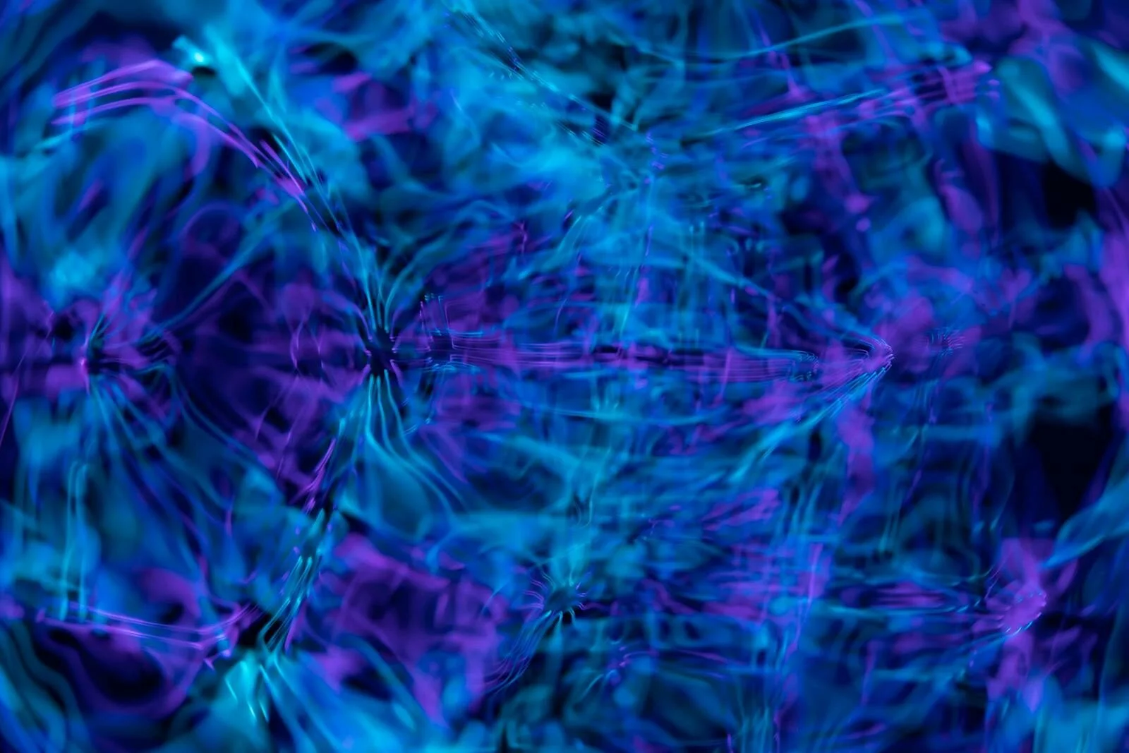 An abstract digital artwork featuring swirling blue and purple waves with a smooth, fluid texture.