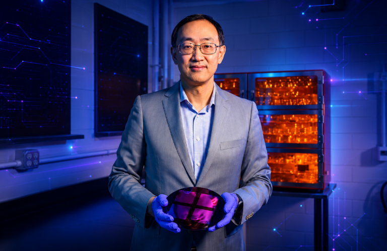 Associate Professor Qing Cao holds a 200-mm wafer covered with multiple layers of vertically stacked silicon membranes. - TQI