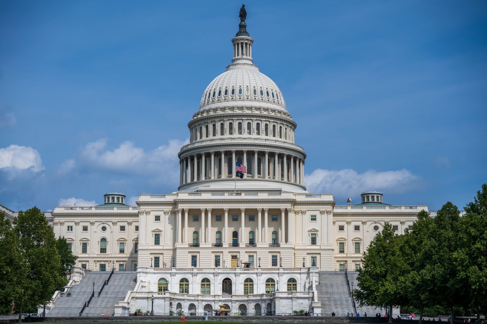A frontal view of the iconic US Capitol Building in Washington D.C. under blue skies.