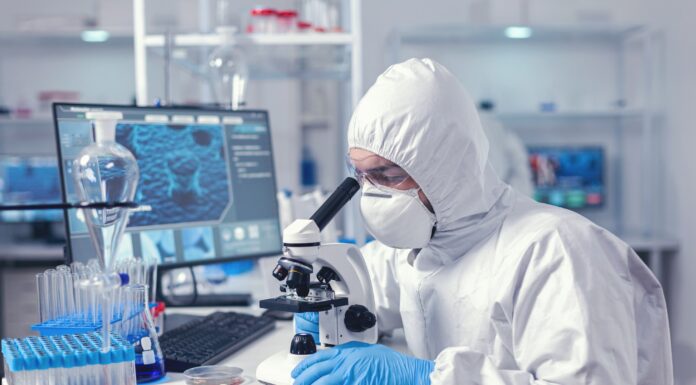 Chemistry scientist looking at sample on glass slide