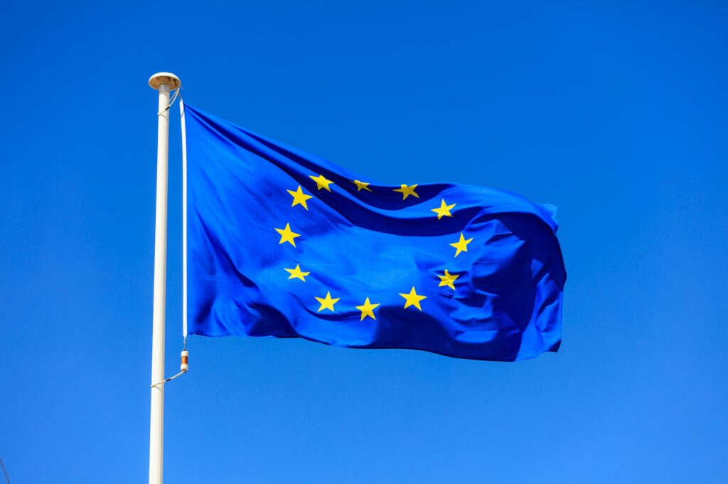 EU flag. European Union flag on a pole waving on blue sky background